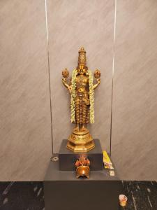 uma estátua de ouro de uma divindade sobre uma mesa em HOTEL PARK RAAMA em Tirupati