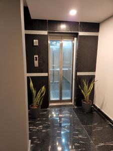 a hallway with potted plants and a glass door at HOTEL PARK RAAMA in Tirupati