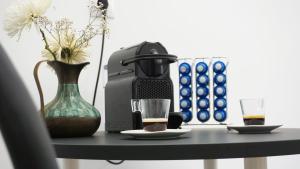 a table with a coffee maker and a vase and a drink at SINTRA STAY - Massamá Guesthouse in Queluz