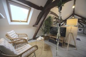 サンスにあるMon Rêve - By BEST KEYS - Loft Cosy & Charme Authentique - Poutres Apparentes - Centre Ville - Netflix & WiFi Fibre - Smart TV - Machine à Café Nespresso - Check-in Autonome - Parking Facile & Gratuitの椅子2脚とテレビのあるリビングルーム