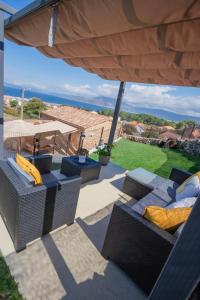 un patio con due sedie e un ombrellone di Tía Amalia - Con vistas al mar a San Mamede de Carnota