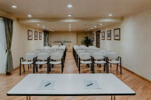 uma sala de conferências com uma fila de cadeiras e mesas em Hotel De La Ville em Florença