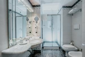 un bagno con lavandino, doccia e WC di Hotel De La Ville a Firenze