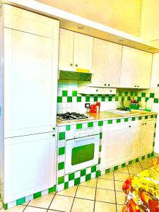 ポッリナにあるAlicudi Suiteの緑と白のタイルの壁のキッチン