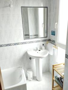 y baño con lavabo, espejo y bañera. en Alto Santiago, en San Vicente de la Barquera
