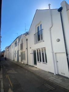 uma fila de edifícios brancos numa rua em Mrs Butler’s Mews House em Brighton & Hove