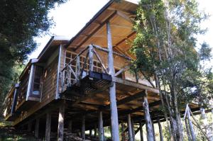 a tree house with a wrap around deck at Cabañas Ecoturismo San Miguel in Queilén