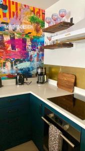 a kitchen counter with a painting on the wall at Mrs Butler’s Mews House in Brighton & Hove
