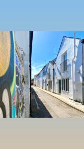 una calle con graffiti en el lateral de un edificio en Mrs Butler’s Mews House en Brighton & Hove