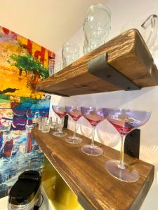 una fila de copas de vino sentadas en un mostrador en Mrs Butler’s Mews House en Brighton & Hove