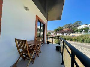 un balcón con una mesa de madera y sillas. en Fabulous Apartment Nazaré, en Nazaré