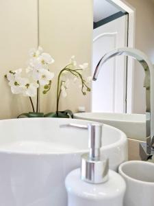 a white bathroom with a sink and a mirror at Laci lak modern apartment in Oradea