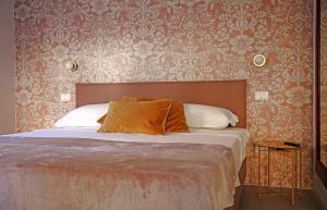 a bedroom with a bed and a wall with wallpaper at Romantic Verona in Verona