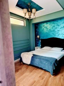 a bedroom with a large bed with a painting on the wall at Laci lak modern apartment in Oradea