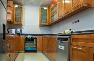 a kitchen with wooden cabinets and a stove at Bansal Villa with Private Pool in Ras al Khaimah