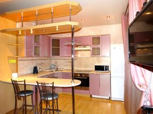 トゥーラにあるInndays Apartments Kaluzhskoe Shosseの紫色のキャビネットとバースツール付きの島が備わるキッチン
