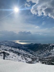 con vistas a una montaña cubierta de nieve y al sol en Al Dolmen, en Monte SantʼAngelo
