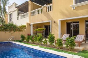 een villa met een zwembad en een huis bij Bansal Villa with Private Pool in Ras al Khaimah