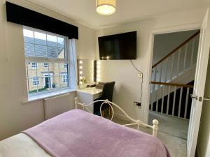 Schlafzimmer mit einem Bett, einem Schreibtisch und einem Fenster in der Unterkunft Holly House - Executive Rural Home with Jacuzzi in Penistone