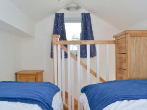 a bedroom with a bed with blue sheets and a window at Langdale Cottage in Chapel Stile