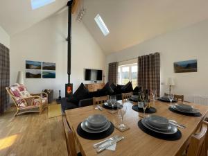 a dining room and living room with a table and chairs at Eagle Landing in Culbokie
