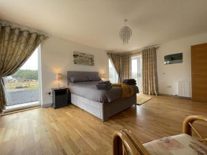 a bedroom with a bed and a large window at Eagle Landing in Culbokie