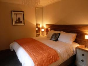 a bedroom with a large bed in a hotel room at Hewlett Apartments in Cheltenham