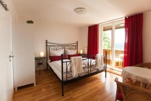 1 dormitorio con cama negra y cortinas rojas en Waldgasthaus Balsamine, en Weimar