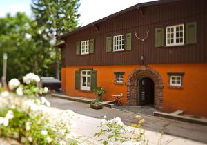 an orange and green house with a building at Waldgasthaus Balsamine in Weimar