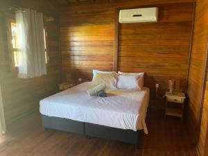 - une chambre avec un lit et un mur en bois dans l'établissement Pousada Wind Rose, à Itarema