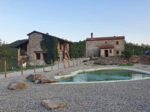 a small pool of water in front of a building at Masia La Clariana in Castelltallat