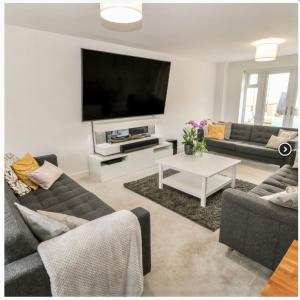 ein Wohnzimmer mit Sofas und einem Flachbild-TV in der Unterkunft Holly House - Executive Rural Home with Jacuzzi in Penistone