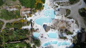uma vista aérea de um parque aquático com piscinas azuis em Apartament Thermae em Bagni San Filippo