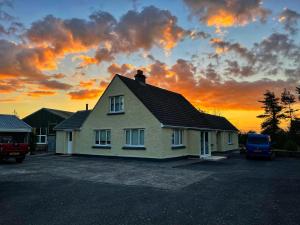 a house in a parking lot with a sunset in the background at Dipples Disabled Access in Haverfordwest