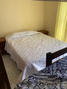 a bedroom with a white bed and a window at Beach house Matapalo Santa Cruz in Matapalo