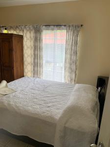 a bedroom with a white bed and a window at Beach house Matapalo Santa Cruz in Matapalo