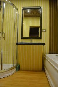 a bathroom with a shower and a sink and a mirror at New York Houseboat in Srinagar