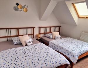 a bedroom with two beds and a window at Penzion ORION in Petrovice