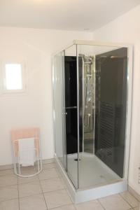 una doccia in vetro in bagno con sedia di Plaisir en baie a Saint-Blimont