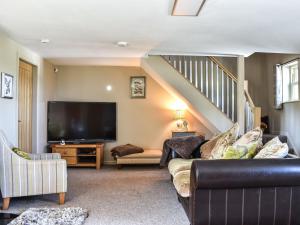 a living room with a couch and a flat screen tv at Hare Cottage in Westgate