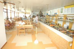 ビージャ・ヘセルにあるAlfil Hotelのレストランのテーブルに人々が座っているキッチン