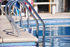 ビージャ・ヘセルにあるAlfil Hotelのスイミングプールの横に座る椅子