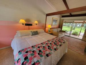 a bedroom with a large bed and a couch at Tropical Marina & Resort on Lake Beresford in De Land