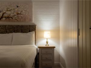 ein Schlafzimmer mit einem Bett und einer Lampe auf einem Nachttisch in der Unterkunft Lodge 2 - Kinnoull in Perth