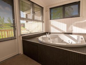 uma casa de banho com banheira e uma grande janela em Lodge 2 - Kinnoull em Perth