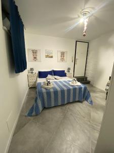 um quarto com uma cama com um cobertor azul e branco em Al Centro di Tutto em Palermo