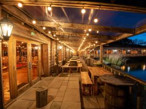 an outdoor patio with wooden tables and lights at Lodge 12 - Hideaway 1 in Perth
