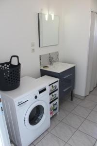 una lavanderia con lavatrice e lavandino di Plaisir en baie a Saint-Blimont