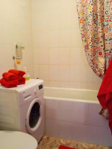 陶拉格的住宿－BuTaS TaUrAgEje，浴室配有洗衣机和浴缸。