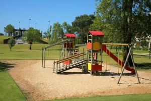 a playground with a slide in a park at Troia Residence by The Editory - Apartamentos Marina in Troia